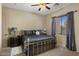 This bedroom showcases a comfortable bed, a ceiling fan, neutral walls, and natural light at 18036 W San Miguel Ave, Litchfield Park, AZ 85340