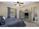 A stylish bedroom featuring a statement bed, a ceiling fan, and decorative display cabinets at 18036 W San Miguel Ave, Litchfield Park, AZ 85340