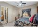 Cozy bedroom with plush carpet, ceiling fan, and window with curtains, adjacent to the main bathroom at 18036 W San Miguel Ave, Litchfield Park, AZ 85340