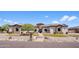 Stunning single-story home featuring manicured lawn, stone accents and tile roof, and a circular turret entrance at 18036 W San Miguel Ave, Litchfield Park, AZ 85340