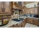 Gourmet kitchen features custom cabinetry, stone countertops, and a stainless-steel gas cooktop at 18036 W San Miguel Ave, Litchfield Park, AZ 85340