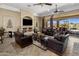 Spacious living room featuring a stone fireplace, leather furniture, and sliding glass doors to the backyard at 18036 W San Miguel Ave, Litchfield Park, AZ 85340