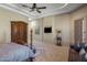 Large main bedroom with tray ceiling, ornate armoire, sitting area, and backyard views at 18036 W San Miguel Ave, Litchfield Park, AZ 85340