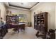 Well-appointed home office featuring custom built-ins, a large desk, and comfortable seating at 18036 W San Miguel Ave, Litchfield Park, AZ 85340