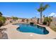 Inviting pool with a rock waterfall feature, palm trees and an outdoor grill at 18036 W San Miguel Ave, Litchfield Park, AZ 85340
