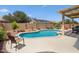 Backyard oasis featuring a private pool, desert landscaping, and a covered seating area at 18242 W Stinson Dr, Surprise, AZ 85374