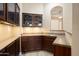 Chic bar area with dark wood cabinets, light countertops, and modern lighting at 18242 W Stinson Dr, Surprise, AZ 85374