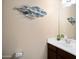 Powder room with a decorative fish art installation, vanity, and mirror at 18242 W Stinson Dr, Surprise, AZ 85374