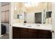 This bathroom includes a double sink vanity with dark wood cabinets and large mirrors at 18242 W Stinson Dr, Surprise, AZ 85374