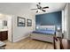 Primary bedroom with blue accent wall, en-suite bathroom, and wood flooring at 18242 W Stinson Dr, Surprise, AZ 85374
