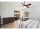 Bright bedroom featuring a ceiling fan, wood flooring, and sliding glass doors leading to an outdoor lounge at 18242 W Stinson Dr, Surprise, AZ 85374