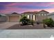 Charming single-story home with desert landscaping, decorative rock, and a two-car garage at 18242 W Stinson Dr, Surprise, AZ 85374