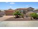 Charming single-story home featuring desert landscaping, a tile roof, and an attached two-car garage at 18242 W Stinson Dr, Surprise, AZ 85374