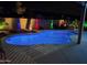 Backyard pool view with custom colored lights and desert landscaping at 18242 W Stinson Dr, Surprise, AZ 85374
