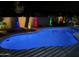 Backyard pool view with desert landscape and custom colored lights for evening relaxation at 18242 W Stinson Dr, Surprise, AZ 85374
