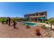 Beautiful backyard featuring a sparkling pool, lush landscaping, and a spacious outdoor seating area at 19427 W Colter St, Litchfield Park, AZ 85340
