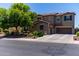 Two-story stucco home featuring a three-car garage, mature landscaping, and a tiled roof at 19427 W Colter St, Litchfield Park, AZ 85340