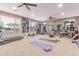 Spacious home gym featuring carpet flooring, ceiling fans, and a full array of exercise equipment and weights at 19427 W Colter St, Litchfield Park, AZ 85340