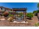 Relaxing hammock nestled beneath a pergola, creating a tranquil outdoor retreat within the landscaped backyard at 19427 W Colter St, Litchfield Park, AZ 85340
