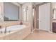 Bathroom with soaking tub, tiled enclosure, and glass block window at 19427 W Colter St, Litchfield Park, AZ 85340