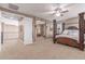 Spacious bedroom with four-poster bed and ceiling fan, and view to hall at 19427 W Colter St, Litchfield Park, AZ 85340