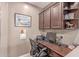 A charming home office with wood desk and cabinets, adorned with a beautiful piece of art and workspace at 19427 W Colter St, Litchfield Park, AZ 85340