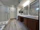 Bathroom with a double sink vanity, walk-in shower, and wood-look tile flooring at 2169 E Bishop Dr, Tempe, AZ 85282