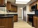 Well-lit kitchen featuring wood cabinets, black countertops, and modern appliances at 2169 E Bishop Dr, Tempe, AZ 85282