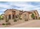 Elegant stone home features desert landscaping, a tile roof, and a three car garage at 2255 N Hillridge --, Mesa, AZ 85207