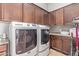 This laundry room features dark wood cabinets, a washer and dryer, counter space, and tile flooring at 2255 N Hillridge --, Mesa, AZ 85207
