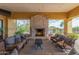 A luxurious outdoor lounge area features a stone fireplace, comfortable seating, and views of the surrounding landscape at 2255 N Hillridge --, Mesa, AZ 85207