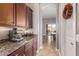This butler's pantry features granite counters, dark wood cabinets, and a view into the dining room at 2255 N Hillridge --, Mesa, AZ 85207