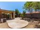 Large concrete patio in backyard with shade cover, rock accents and trees at 2421 W Romley Rd, Phoenix, AZ 85041