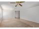 Expansive living room features neutral carpet, tile flooring, ceiling fan, and great natural light at 2421 W Romley Rd, Phoenix, AZ 85041