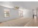 Bright living room boasts neutral carpet, tile flooring, large windows, and a ceiling fan at 2421 W Romley Rd, Phoenix, AZ 85041