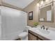 Bright bathroom features a framed mirror, a shower with curtain, and wood grain vanity at 3373 W Five Mile Peak Dr, San Tan Valley, AZ 85144