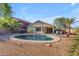A refreshing backyard pool is surrounded by desert landscaping and lush palm trees, perfect for relaxing and enjoying the Arizona sun at 3373 W Five Mile Peak Dr, San Tan Valley, AZ 85144