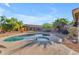 Backyard pool with surrounding desert landscaping, unique wall art, and blue skies at 3373 W Five Mile Peak Dr, San Tan Valley, AZ 85144