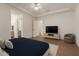 Bright bedroom with hard floors, modern ceiling fan, TV, and an en-suite bathroom at 3438 W Little Hopi Dr, Phoenix, AZ 85086