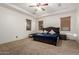 Comfortable bedroom with a ceiling fan, plush carpet, and warm lighting at 3438 W Little Hopi Dr, Phoenix, AZ 85086