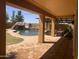 Backyard pool area with a covered patio, rock waterfall feature and lush landscaping at 35743 W Cartegna Ln, Maricopa, AZ 85138