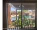 Pool view with a rock slide and lush landscaping, as seen through the window at 35743 W Cartegna Ln, Maricopa, AZ 85138