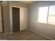 A bedroom with carpet, light gray walls, window, and closet at 35743 W Cartegna Ln, Maricopa, AZ 85138