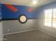 Themed bedroom featuring custom paint and a window with natural light on carpet flooring at 35743 W Cartegna Ln, Maricopa, AZ 85138