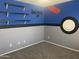 Themed bedroom featuring custom paint, floating shelves, and carpet flooring at 35743 W Cartegna Ln, Maricopa, AZ 85138