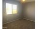 A bedroom with carpet, light gray walls, and a window at 35743 W Cartegna Ln, Maricopa, AZ 85138