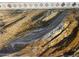 Close-up of unique granite countertops with a swirling pattern of gold, black, gray, and brown tones at 35743 W Cartegna Ln, Maricopa, AZ 85138