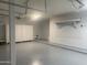 Spacious garage featuring epoxy floors, storage cabinets, overhead racks, and a pegboard wall at 35743 W Cartegna Ln, Maricopa, AZ 85138
