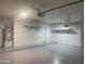 Bright garage featuring epoxy floors, shelving, and a modern garage door opener at 35743 W Cartegna Ln, Maricopa, AZ 85138