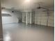 View of a spacious garage with an epoxy floor and multiple garage doors at 35743 W Cartegna Ln, Maricopa, AZ 85138